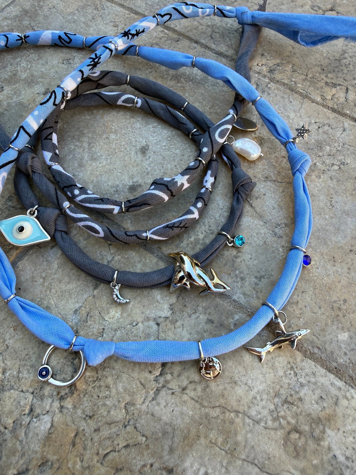 Set of necklaces with charms on a textured stone surface